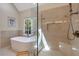 Bright bathroom featuring a soaking tub under a window and a frameless walk-in shower at 116 Berry Hill Dr, Raleigh, NC 27615