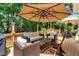 Outdoor deck featuring ample seating beneath shade umbrellas and a wooded view at 116 Berry Hill Dr, Raleigh, NC 27615