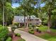 Stately brick home with manicured lawn and garden beds leads to long driveway at 116 Berry Hill Dr, Raleigh, NC 27615