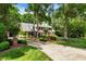 Brick home with mature trees, lush lawn, and landscaped front yard at 116 Berry Hill Dr, Raleigh, NC 27615