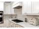 Close up of a modern kitchen featuring white cabinets, quartz countertops, and stainless steel appliances at 116 Berry Hill Dr, Raleigh, NC 27615