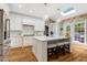 Bright, modern kitchen with a large island, white cabinetry, and hardwood floors at 116 Berry Hill Dr, Raleigh, NC 27615