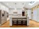 Bright, modern kitchen with a large island, white cabinetry, and hardwood floors at 116 Berry Hill Dr, Raleigh, NC 27615