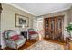 Comfortable living room featuring hardwood floors, an antique cabinet, and patterned chairs at 116 Berry Hill Dr, Raleigh, NC 27615