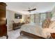 This main bedroom features neutral walls, a ceiling fan, a mounted tv and two large windows at 116 Berry Hill Dr, Raleigh, NC 27615
