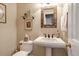 Well decorated powder room featuring a pedestal sink, decorative mirror, and neutral tones at 116 Berry Hill Dr, Raleigh, NC 27615