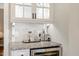 Granite countertop wet bar features a wine fridge and decorative glassware at 116 Berry Hill Dr, Raleigh, NC 27615