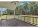 Covered wooden porch showcasing a view of the backyard surrounded by mature trees at 119 Blossom Creek Dr, Garner, NC 27529