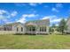 Exterior view of the back of the house with a lush green lawn and blue sky at 119 Blossom Creek Dr, Garner, NC 27529