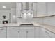 Modern kitchen with white cabinets, stone countertops, subway tile backsplash, and stainless steel hood at 119 Blossom Creek Dr, Garner, NC 27529