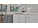 Modern kitchen featuring white cabinets, stainless steel appliances, and stone countertops with a view to the fireplace at 119 Blossom Creek Dr, Garner, NC 27529