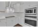 Modern kitchen featuring white cabinets, stainless steel appliances, stone countertops, and a built in oven and microwave at 119 Blossom Creek Dr, Garner, NC 27529
