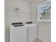 Well-lit laundry room with modern washer and dryer, shelving, and a window letting in natural light at 119 Blossom Creek Dr, Garner, NC 27529