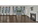 Living room featuring a fireplace, hardwood floors, and a view of the backyard through large windows at 119 Blossom Creek Dr, Garner, NC 27529
