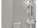 Clean half-bathroom featuring a pedestal sink, toilet, and modern lighting at 119 Blossom Creek Dr, Garner, NC 27529