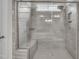 Modern bathroom shower featuring tiled walls, a glass door, and a built-in bench for added comfort at 119 Blossom Creek Dr, Garner, NC 27529
