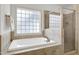 Bright bathroom featuring a soaking tub with tile surround and a separate glass-enclosed shower at 1217 Chalk Maple Dr, Cary, NC 27519