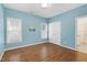 Bright bedroom with blue walls, hardwood floors and natural light from the windows at 1217 Chalk Maple Dr, Cary, NC 27519