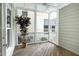 Cozy screened porch with wooden floors, white trim, and a leafy potted plant at 1217 Chalk Maple Dr, Cary, NC 27519