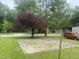 Backyard area featuring a concrete pad, trees, and an older car at 1256 Planters St, Rocky Mount, NC 27801