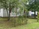 Property featuring mature trees, vinyl siding, and red window shutters at 1256 Planters St, Rocky Mount, NC 27801