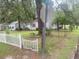 Home surrounded by mature trees, a classic fence, and manicured landscaping at 1256 Planters St, Rocky Mount, NC 27801