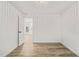 White bedroom featuring a window, door, and hardwood floors at 1621 N Park Ave, Burlington, NC 27217