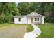An exterior view of a quaint home, featuring white siding and a gravel area on the lawn at 1621 N Park Ave, Burlington, NC 27217