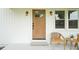 Close up of charming front porch with farmhouse style door, modern sconces and stylish seating at 1621 N Park Ave, Burlington, NC 27217