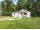 Charming renovated cottage with a manicured lawn, inviting walkway and rocking chair front porch at 1621 N Park Ave, Burlington, NC 27217