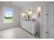 Bright bathroom with dual vanities, white cabinetry, and a large window offering pleasant outdoor views at 1672 Wheeler Dr, Angier, NC 27501