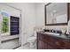 Elegant bathroom features a dark wood vanity with black marble countertop, tile flooring, and walk-in closet at 1672 Wheeler Dr, Angier, NC 27501