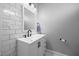 Modern bathroom with subway tile walls, a white vanity, sleek black fixtures, and marble floors at 1672 Wheeler Dr, Angier, NC 27501