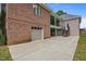 Brick exterior featuring a garage and upper porch at 1672 Wheeler Dr, Angier, NC 27501