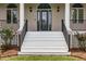 Inviting front entry with white steps, decorative door, and classic black railings at 1672 Wheeler Dr, Angier, NC 27501