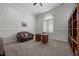 Bright office featuring a large arched window, cozy brown leather couch, and a classic wood desk at 1672 Wheeler Dr, Angier, NC 27501