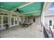Covered porch with ceiling fans, ample seating, and outdoor dining area at 1672 Wheeler Dr, Angier, NC 27501