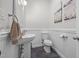 Cozy powder room featuring a pedestal sink, toilet, wainscoting, and stylish decor at 1672 Wheeler Dr, Angier, NC 27501