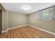 A simple bedroom with neutral walls and hardwood floors, illuminated by a single window at 1705 Nottingham Rd, Raleigh, NC 27607