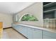The bright kitchen features custom cabinetry, ample counter space and a large arched window framing the outdoors at 1705 Nottingham Rd, Raleigh, NC 27607