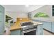 Modern kitchen features updated appliances, a cooktop island, and a unique arched window providing natural light at 1705 Nottingham Rd, Raleigh, NC 27607