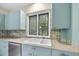 Updated kitchen features stylish cabinets, stainless dishwasher, and a window overlooking the yard at 1705 Nottingham Rd, Raleigh, NC 27607