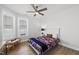 Bright bedroom featuring a ceiling fan, hardwood floors, and a cozy sports-themed bed at 1727 Pinecliff Ct, Fuquay Varina, NC 27526