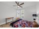 Bright bedroom featuring a ceiling fan, hardwood floors, and a cozy sports-themed bed at 1727 Pinecliff Ct, Fuquay Varina, NC 27526