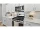 Kitchen with stainless steel appliances, white cabinets, quartz countertops, and a marble backsplash at 1727 Pinecliff Ct, Fuquay Varina, NC 27526