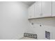 Bright laundry room with cabinets, tile floor, and appliances connections at 1727 Pinecliff Ct, Fuquay Varina, NC 27526