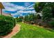 Serene backyard featuring a lush green lawn, trees, and a wooden fence at 1831 Middlebrook Dr, Raleigh, NC 27615