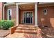 Elegant brick home featuring a charming front porch and a welcoming black front door with wreath at 1831 Middlebrook Dr, Raleigh, NC 27615