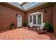 Inviting outdoor patio with brick flooring, chairs, and a garden view, creating a perfect spot for relaxation and gatherings at 1831 Middlebrook Dr, Raleigh, NC 27615