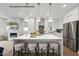 Modern kitchen features an island with seating, stainless steel appliances, and a stylish backsplash for a sophisticated culinary experience at 219 Woodsborough Pl, Raleigh, NC 27601